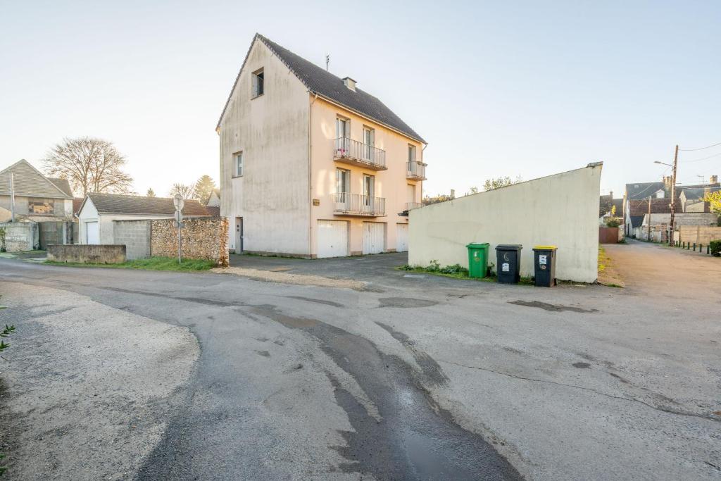 an empty street with a house and two trash cans at Welcome perche ! Appartements 3 étoiles à NOGENT le Rotrou in Nogent-le-Rotrou