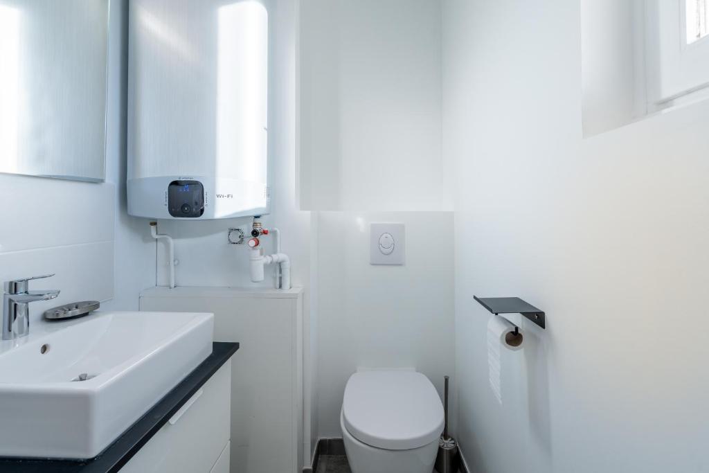 a white bathroom with a sink and a toilet at Welcome perche ! Appartements 3 étoiles à NOGENT le Rotrou in Nogent-le-Rotrou