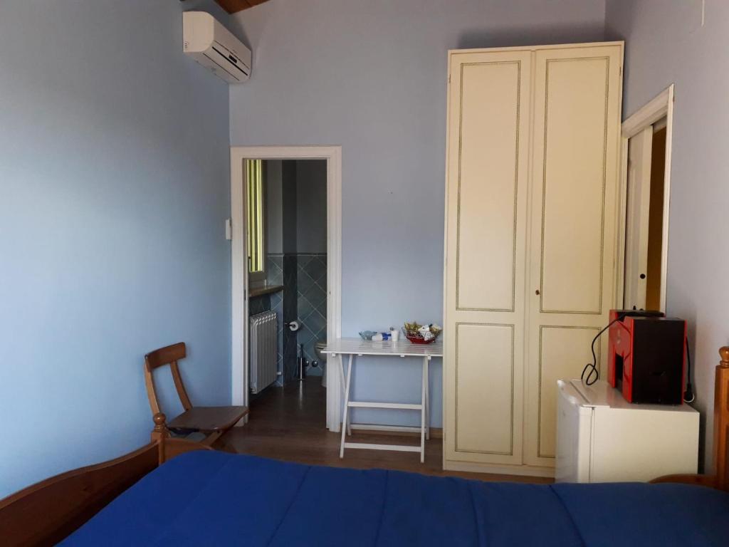 a bedroom with a bed and a table and a door at bed & breakfast CASA JO in Lapedona