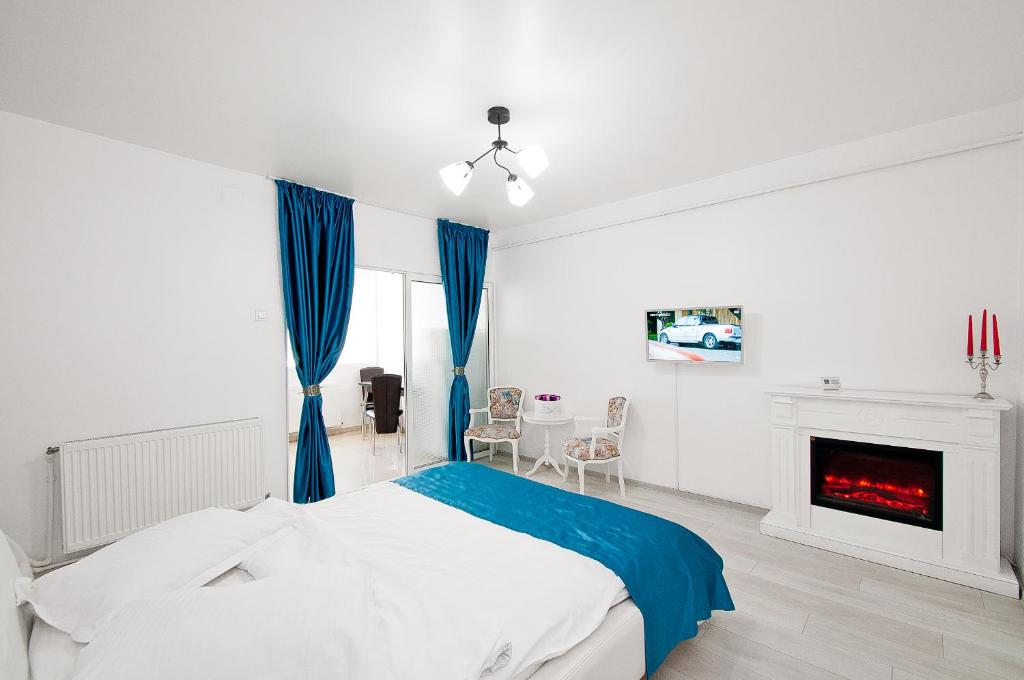 een witte slaapkamer met een bed en een open haard bij Blue Studio in Galaţi