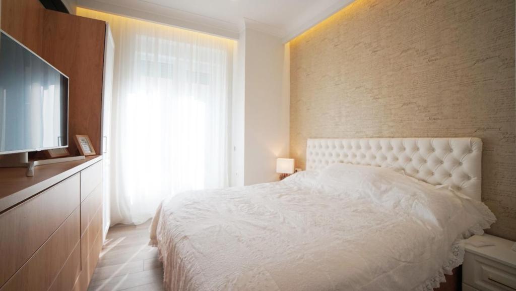 sypialnia z białym łóżkiem i oknem w obiekcie City apartments T w mieście Satu Mare