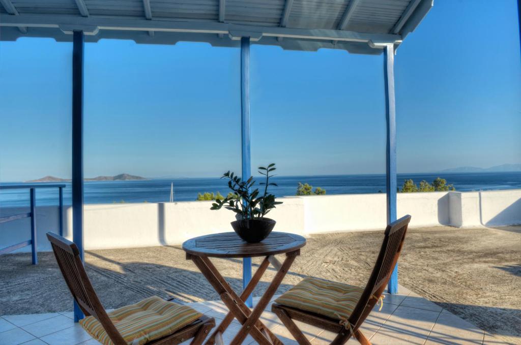 a table and chairs with a view of the beach at Kalithea Studios in Patitiri