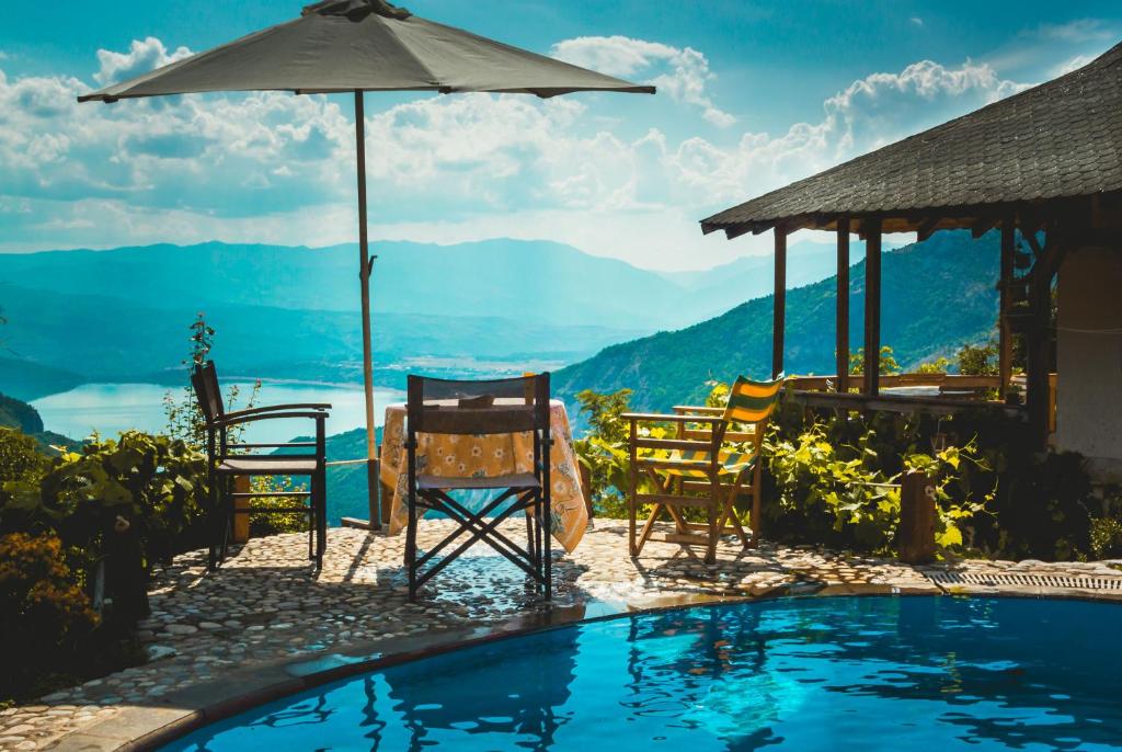 a resort with a pool and chairs and an umbrella at Villa Gorno Melnicani in Debar