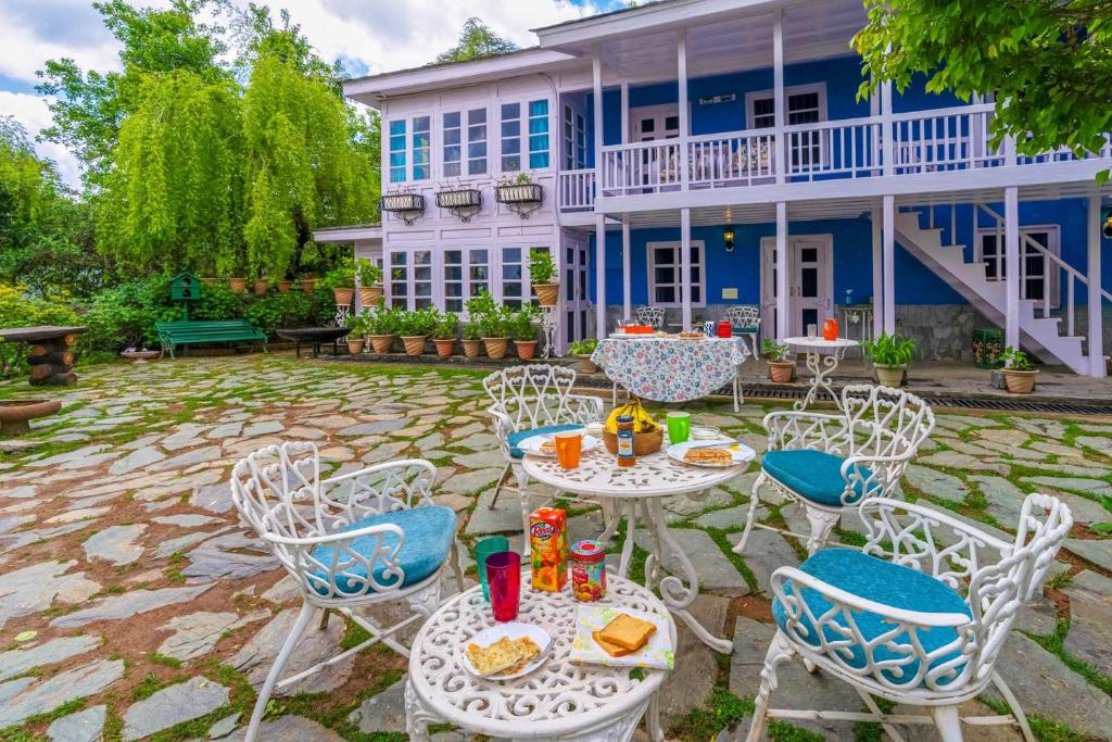 a patio with tables and chairs in front of a house at StayVista at Violet Hill in Shimla