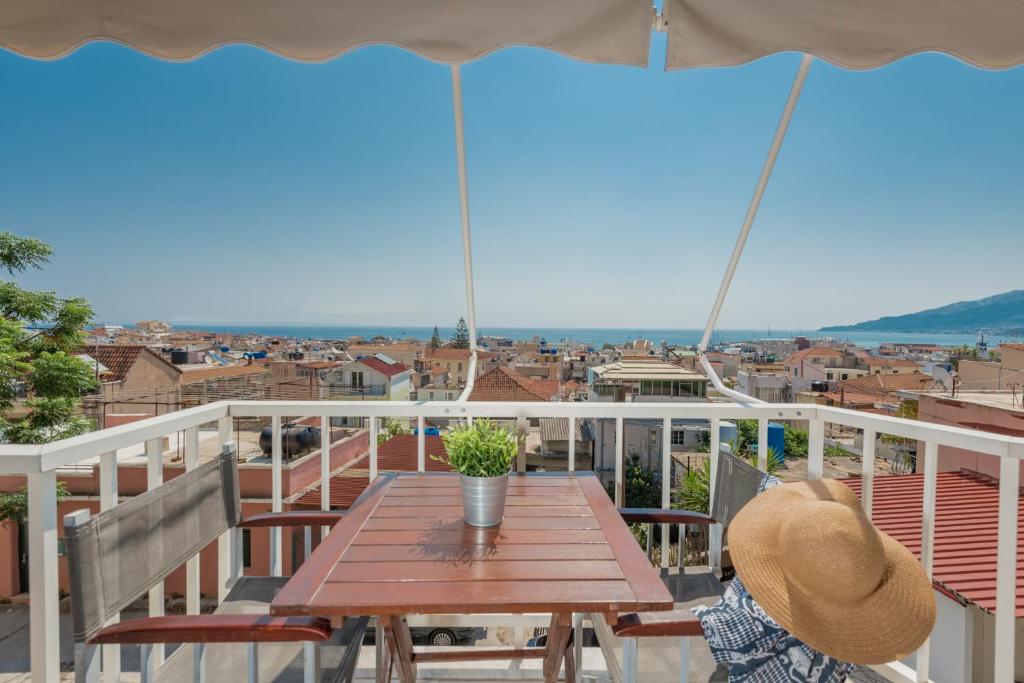 a person sitting at a wooden table on a balcony at Phoenix Apartments - B2 & B3 in Zakynthos Town