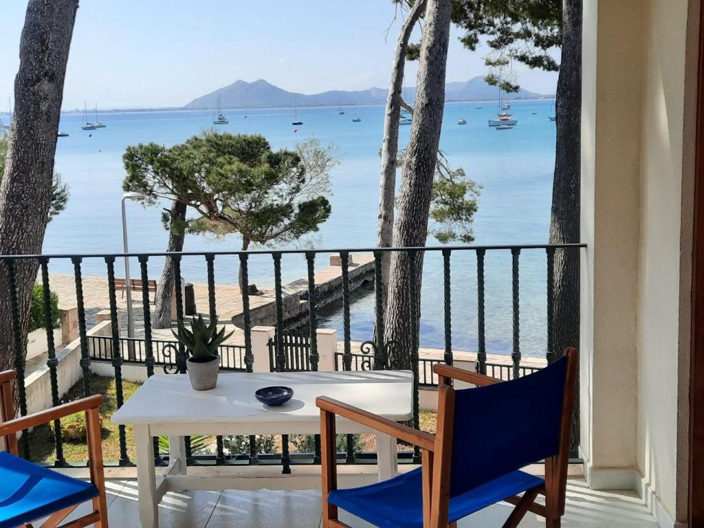 een tafel en stoelen op een balkon met uitzicht op de oceaan bij Port Pollensa Pins Apartment sea view in Port de Pollença