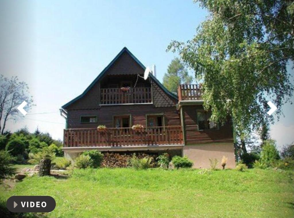 a large house with a deck on the side of it at Nabízím chatu na pronájem in Komňa