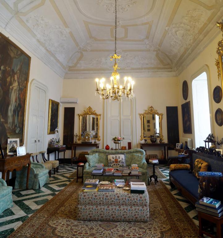 a living room with couches and a chandelier at Palazzo Bernardini Suites in Lecce