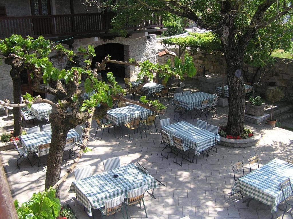un gruppo di tavoli e sedie in un patio di Guesthouse Domacija Sajna a Sežana