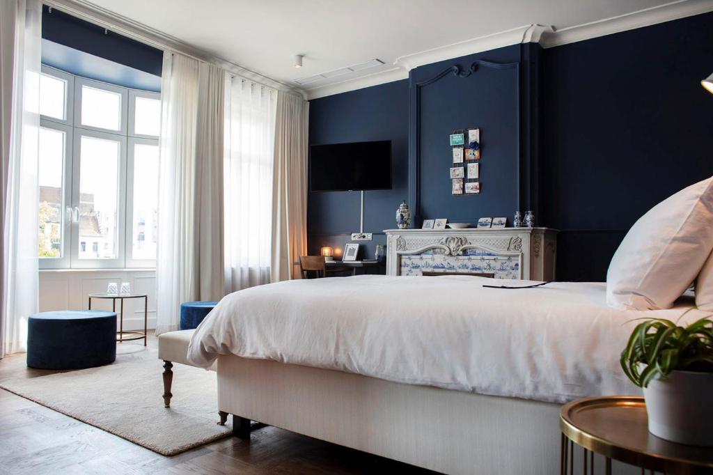 ein Schlafzimmer mit einem großen Bett und blauen Wänden in der Unterkunft Broel4 in Kortrijk