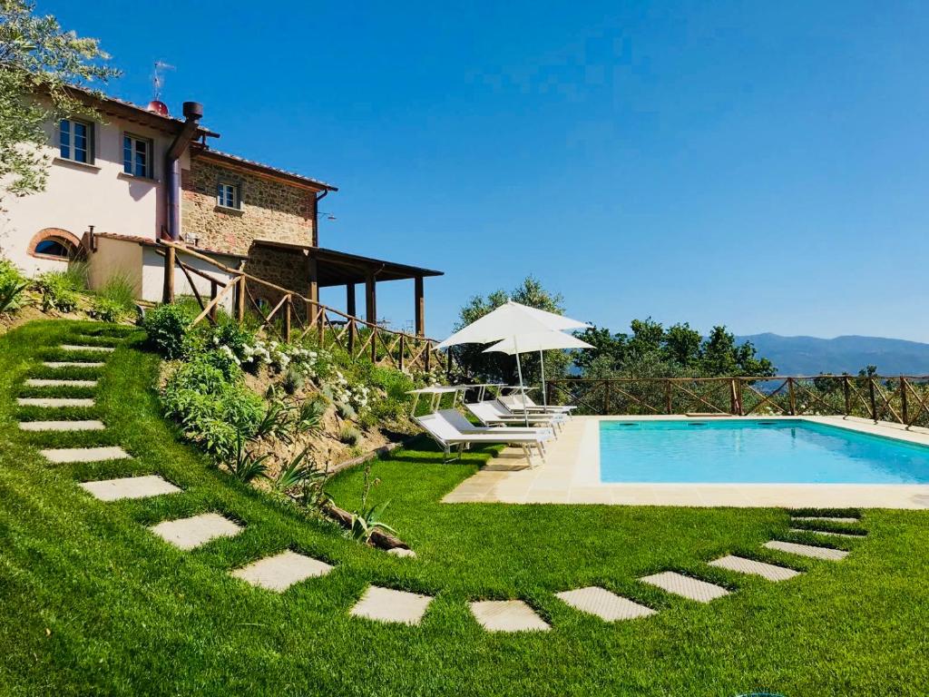 uma villa com uma piscina e uma casa em Villa La Castellina em Cavriglia