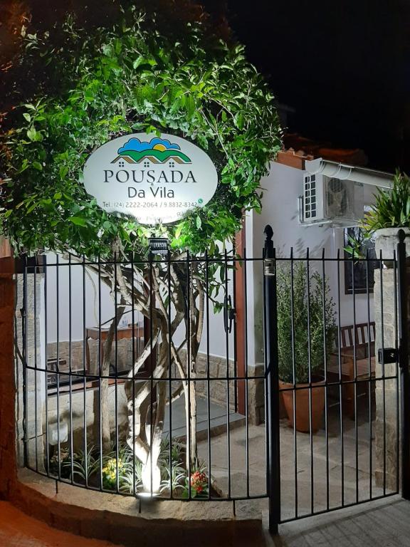 um portão com um sinal que diz pueblo da vita em Pousada da Vila em Itaipava
