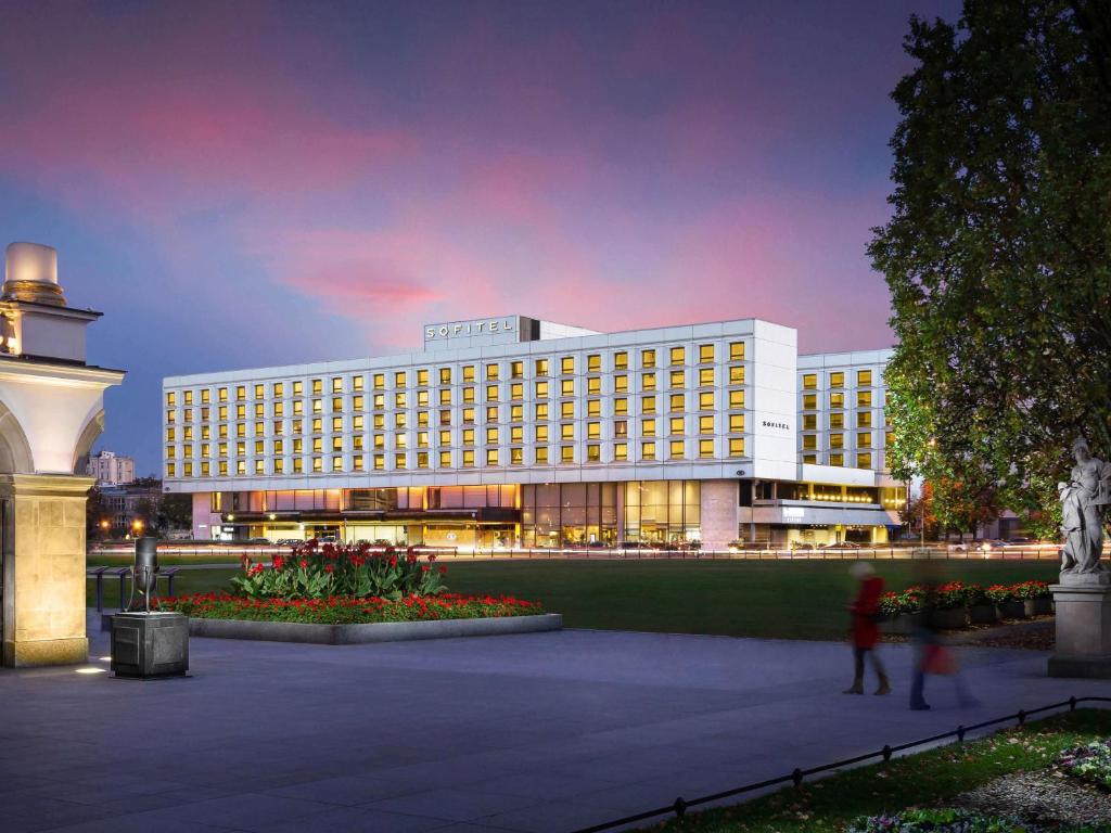 a large white building with a building at night at Sofitel Warsaw Victoria in Warsaw