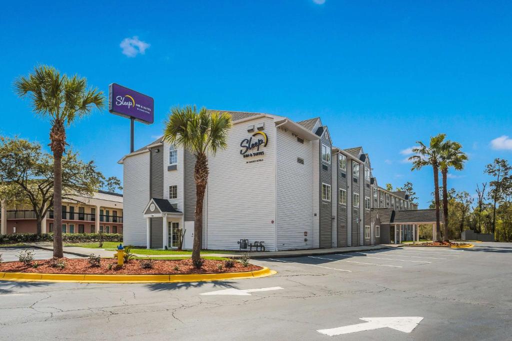 a hotel with palm trees in a parking lot at Sleep Inn & Suites Tallahassee - Capitol in Tallahassee