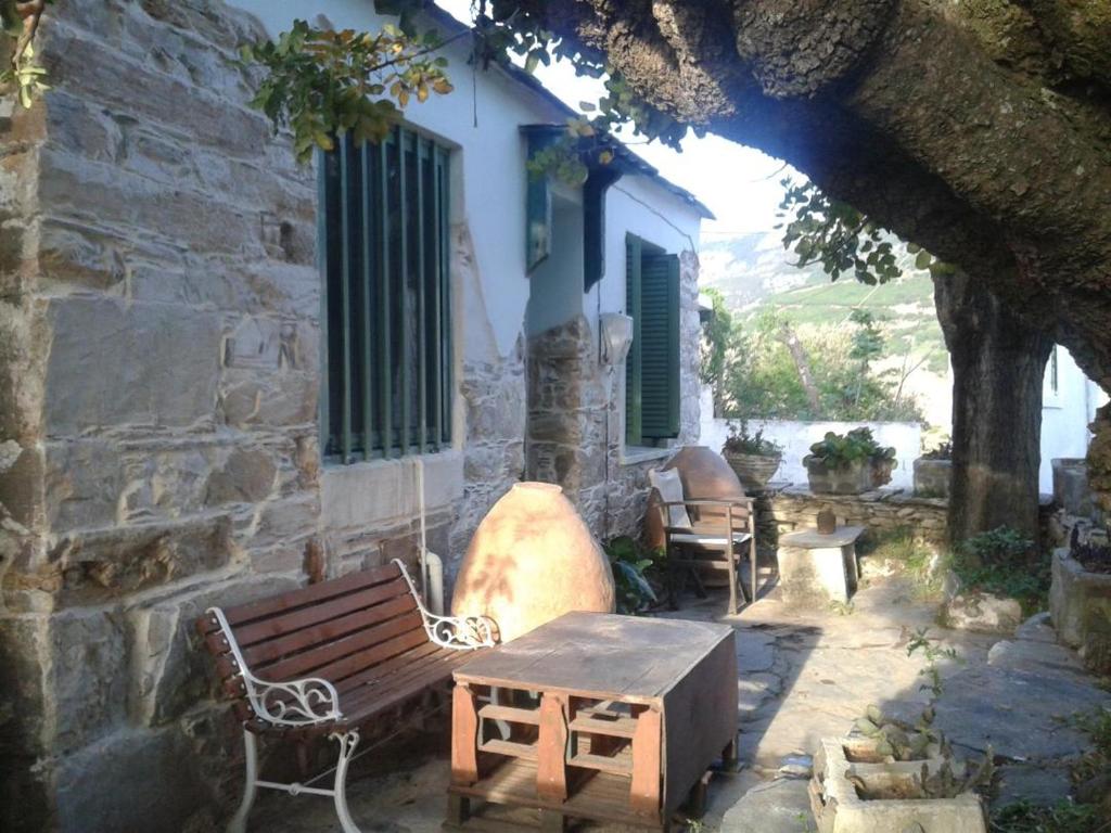 um banco e uma mesa em frente a um edifício em Stoneworld em Evdilos