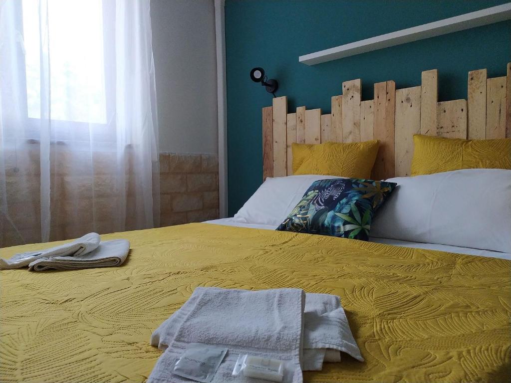 um quarto com uma cama amarela e uma cabeceira em madeira em Bed & Breakfast Pintadera em Santa Maria la Palma