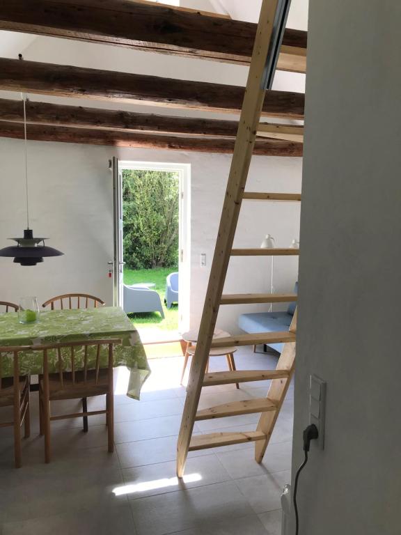 una escalera en una habitación con mesa y sillas en Landlig idyl - direkte til golfbane, en Slagelse