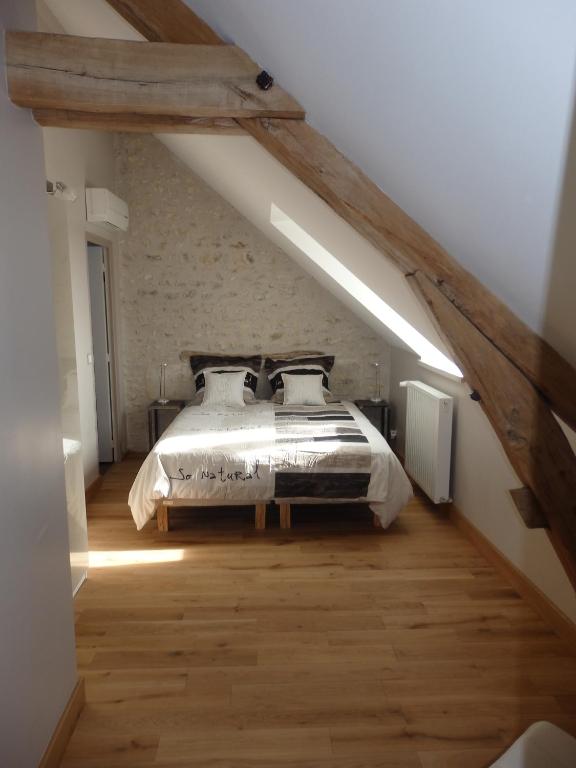 a bedroom with a bed in a attic at Gîte Les Nymphéas in Épeigné-les-Bois