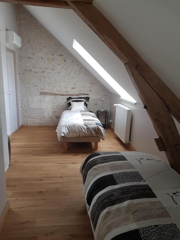 a bedroom with a bed in a attic at Gîte Les Nymphéas in Épeigné-les-Bois