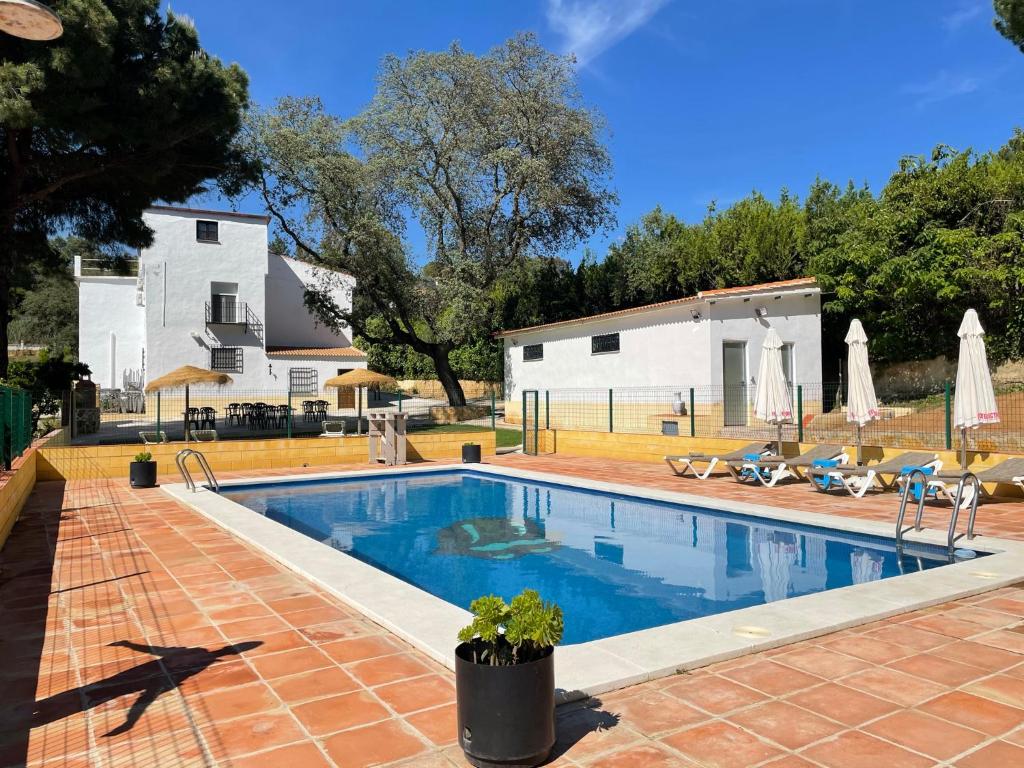 a swimming pool in front of a house at CASA RURAL VlLLA ALGABA in Córdoba