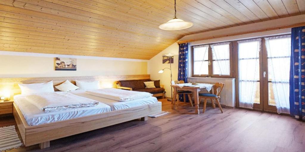 a bedroom with a large bed and a table at Landhaus Petra in Bad Füssing