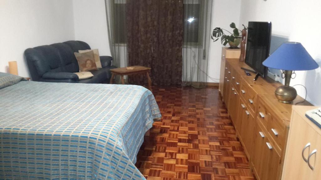 a bedroom with a bed and a dresser with a tv at Quartos Cesário Verde Massamá in Queluz