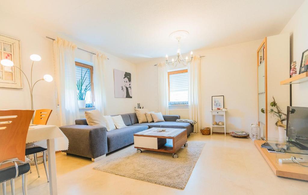 a living room with a blue couch and a table at Ferienwohnung am Ilztal in Hutthurm