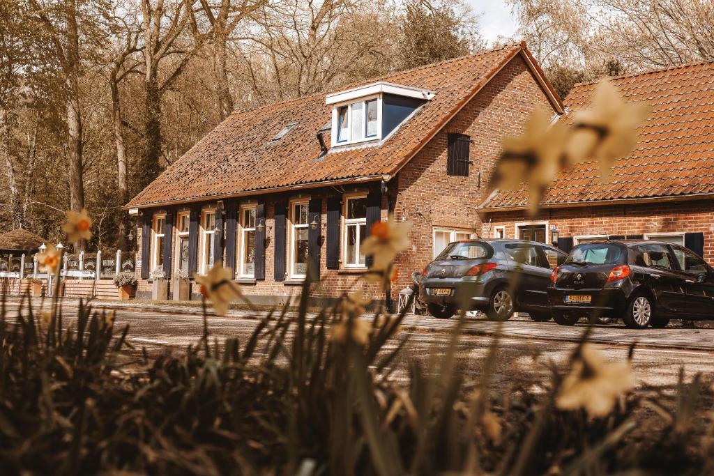 two cars parked in front of a brick building at Hotel 't Welink in Dinxperlo