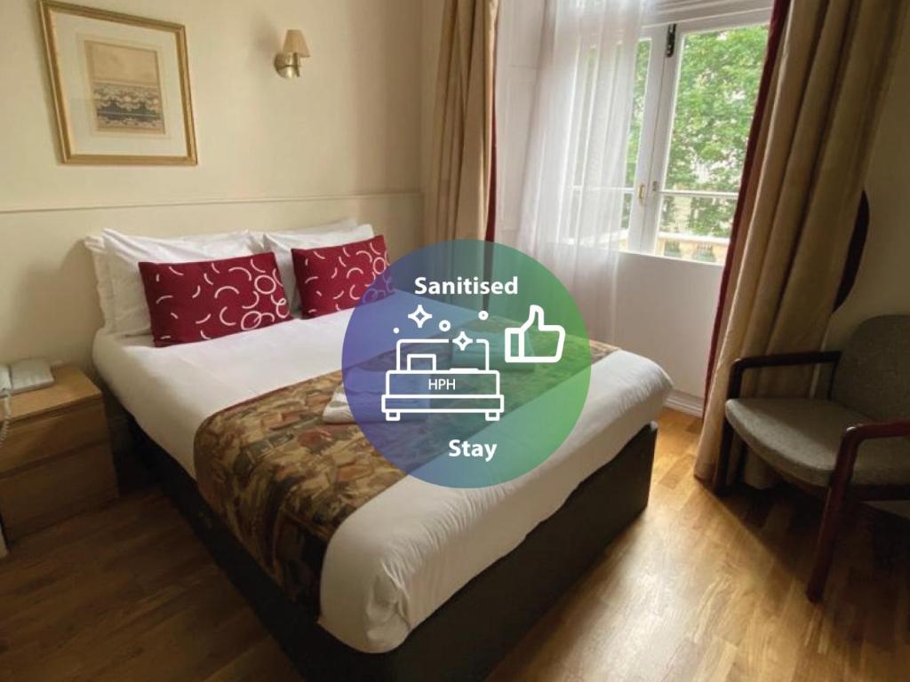 a hotel room with a bed with the words smiledstay and a window at Rose Park Hotel in London