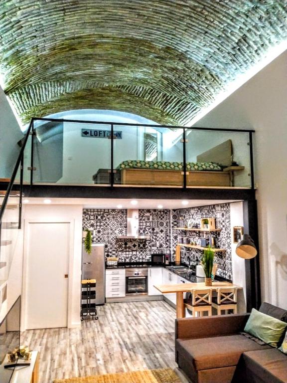 a living room with a couch and a kitchen at Loft Porte Sud in Olhão