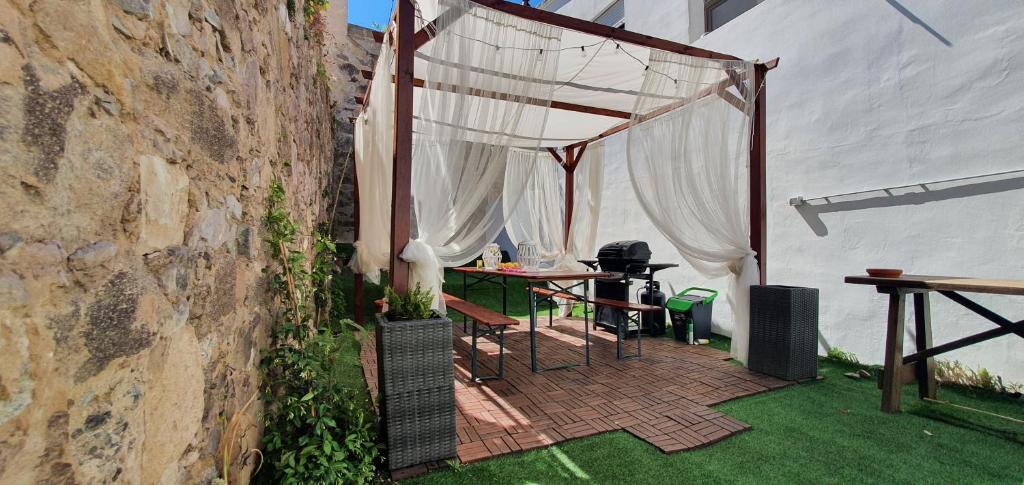 un patio al aire libre con mesa y dosel en Appartamento in Piazza Italia, en SantʼAntìoco