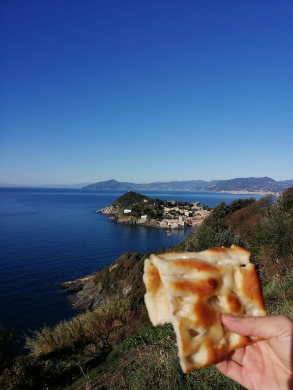 a person holding a piece of pizza in front of the ocean at Hotel Sereno in Sestri Levante