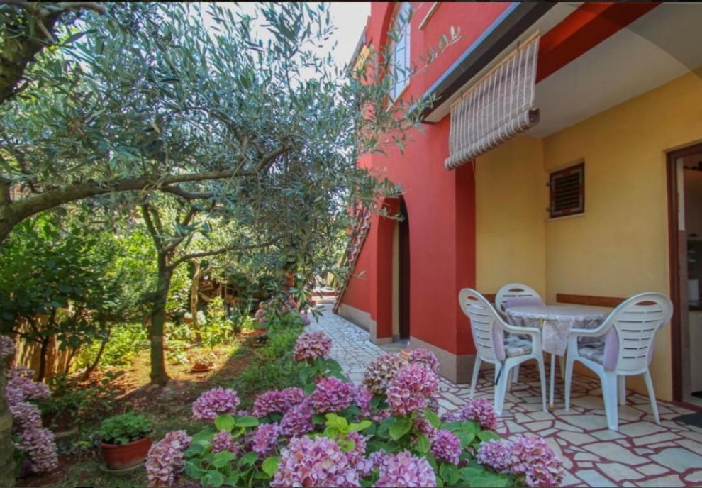 eine Terrasse mit einem Tisch, Stühlen und Blumen in der Unterkunft Valentina in Novigrad Istria