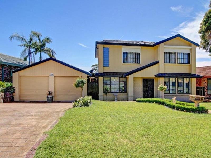 een groot geel huis met een garage bij Horsley Retreat in Dapto