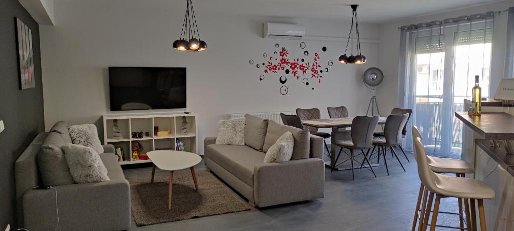uma sala de estar com um sofá e uma mesa em IKON apartman em Hajdúszoboszló