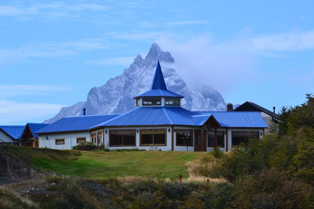 a house with a mountain in the background at Hotel Los Ñires in Ushuaia