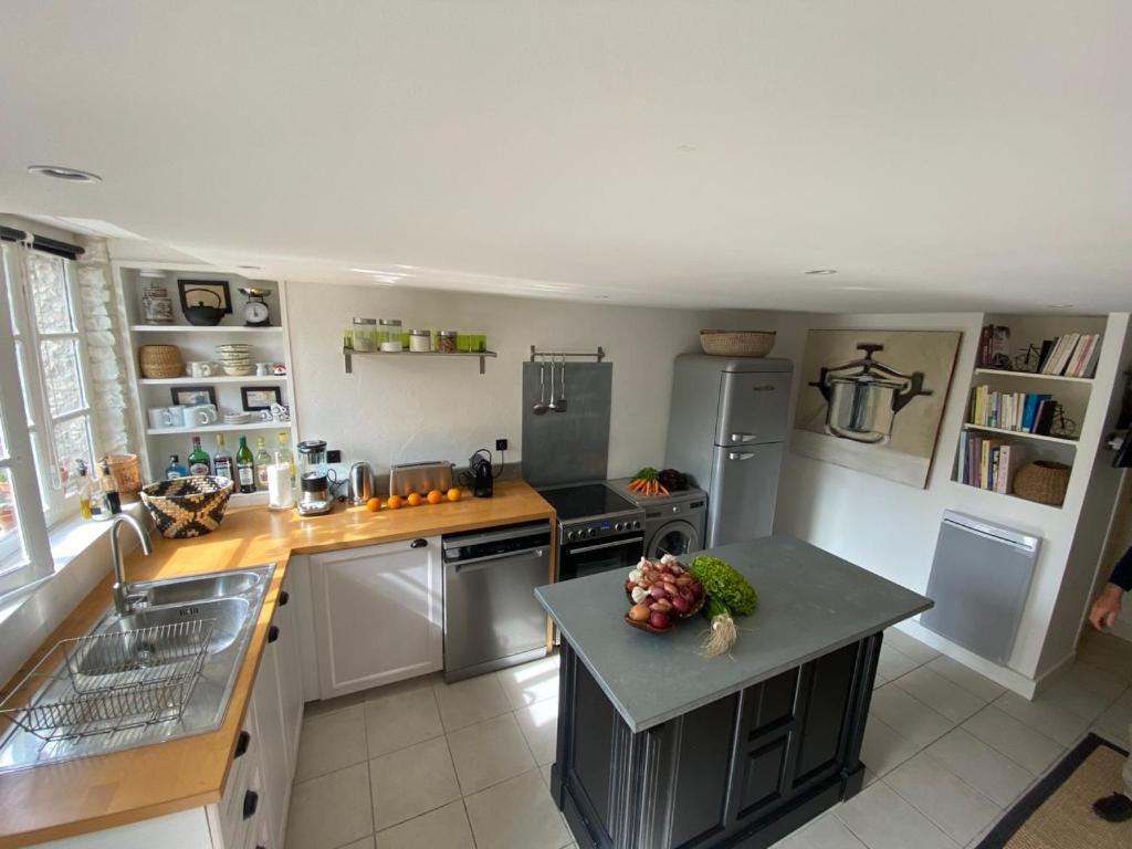 a kitchen with stainless steel appliances and a counter top at Le Jardin de Fileraise Pour un couple in Le Bois-Plage-en-Ré