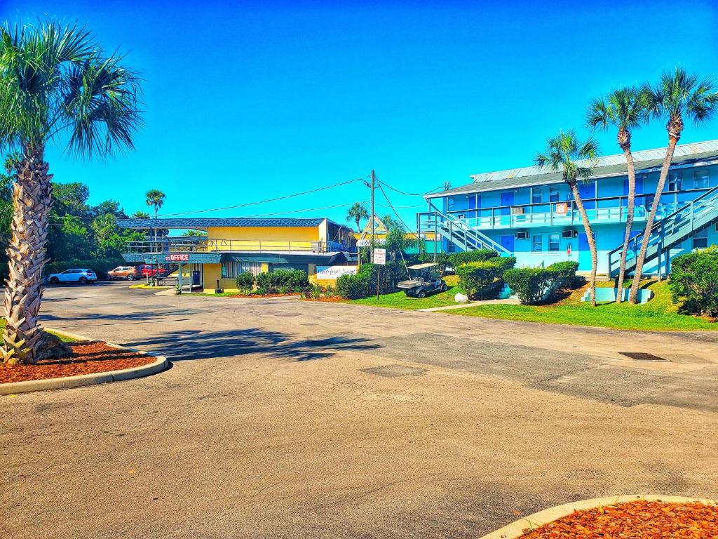 pusty parking przed budynkiem z palmami w obiekcie The Port Hotel and Marina w mieście Crystal River