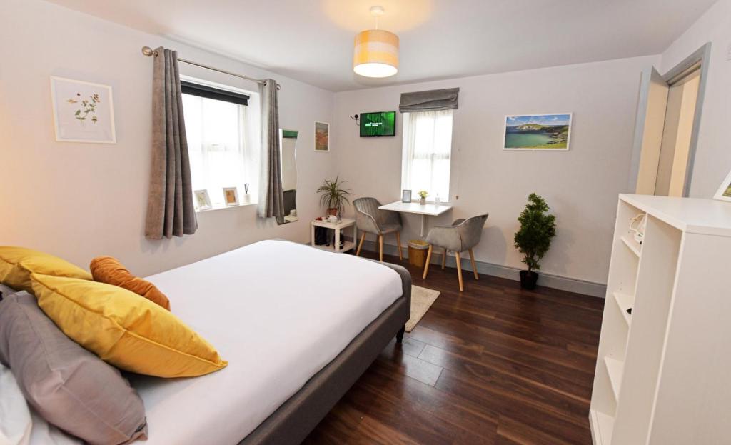 a bedroom with a bed and a table and chairs at Pier House Room in Dingle