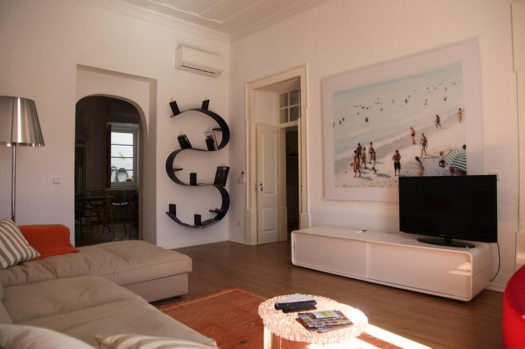 a living room with a couch and a flat screen tv at Tavira Home in Tavira