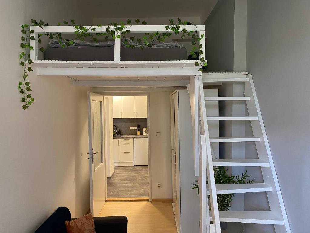 a loft bed with a ladder in a room at Downtown Flat under Spilberk Castle in Brno