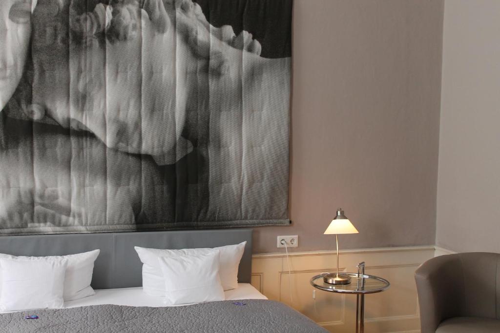ein Schlafzimmer mit einem Bett und einem Wandgemälde in der Unterkunft Palais Schrottenberg in Bamberg