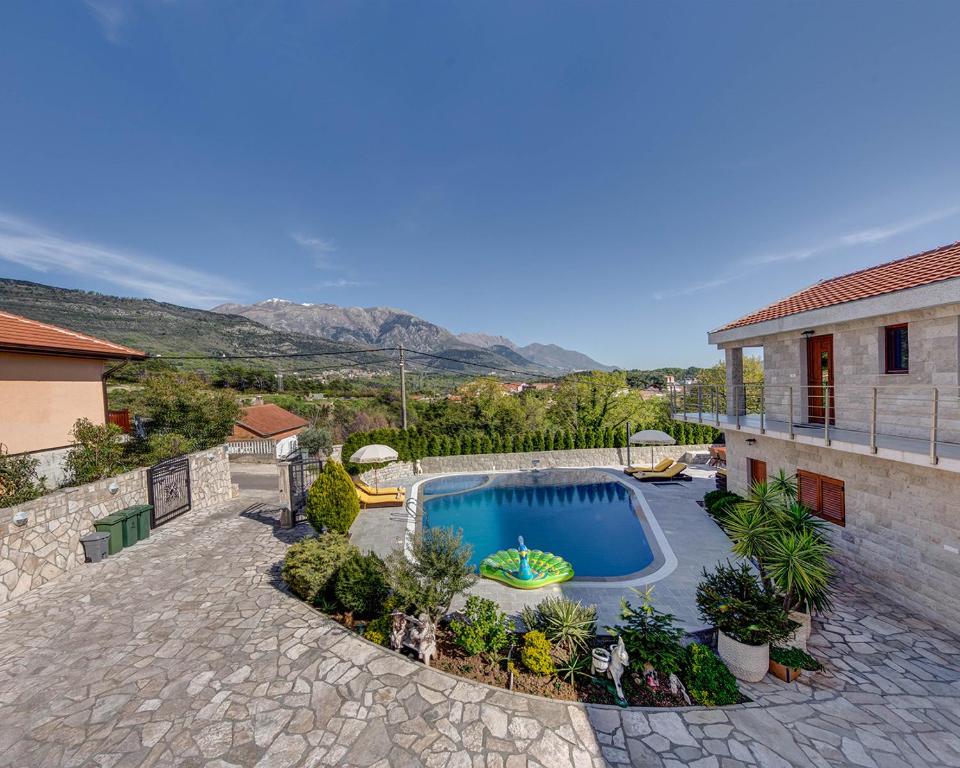 a swimming pool in a yard next to a house at Villa Ilijana in Tivat