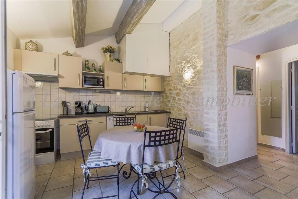 een keuken met een tafel en stoelen in een kamer bij L'Arc en Ciel in Gréoux-les-Bains