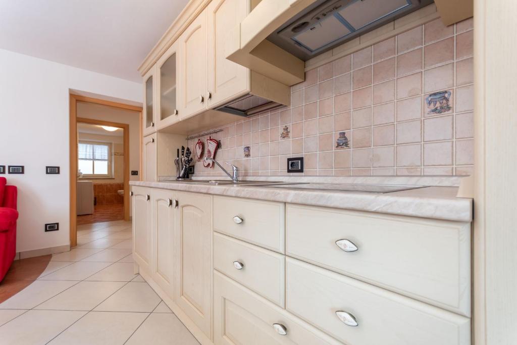 a kitchen with white cabinets and a sink at Chalet Butterfly 2 in Mazzin