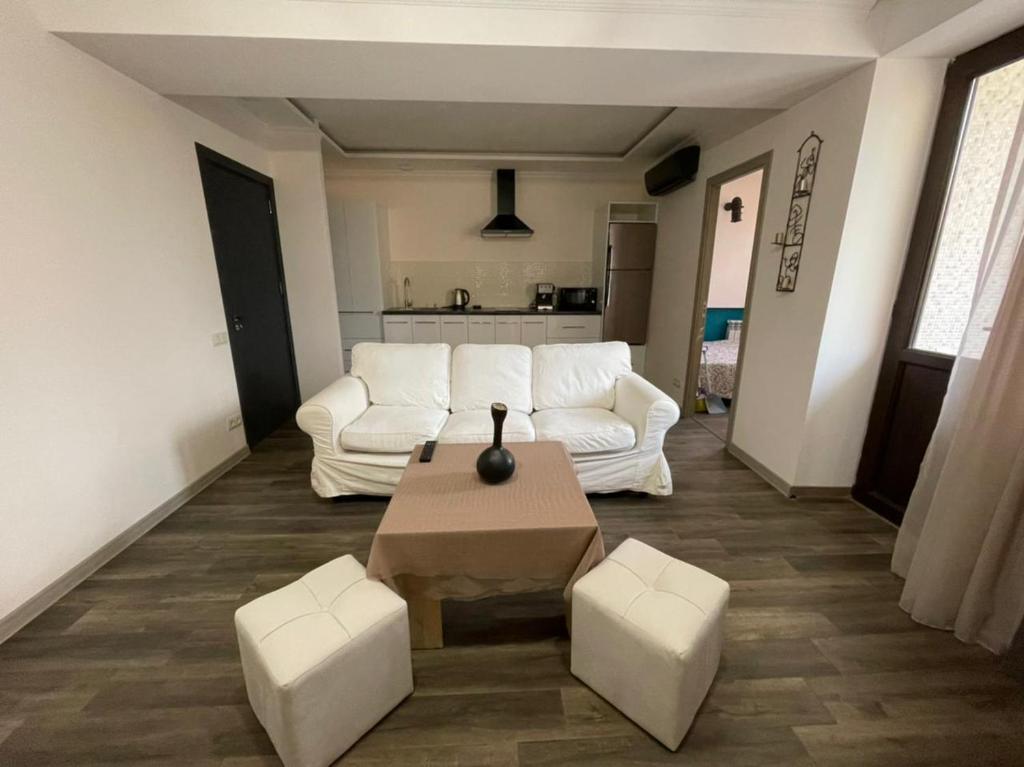 a living room with a white couch and a table at CITY VIEW PENTHOUSE in Yerevan