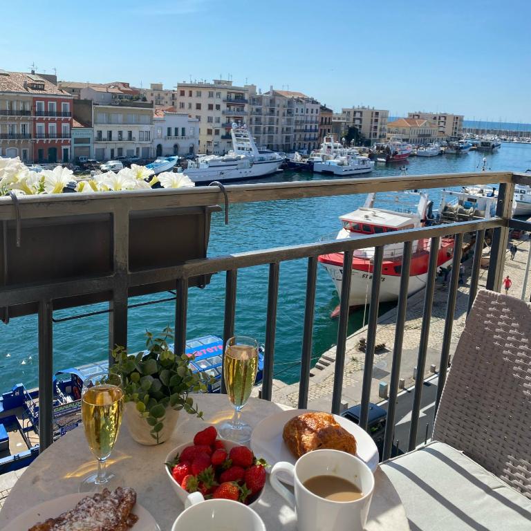 - une table avec de la nourriture et des boissons sur un balcon avec un port dans l'établissement Le Petit Bijou Sète, 4 appartements au centre ville, 3 avec vue canal, à Sète