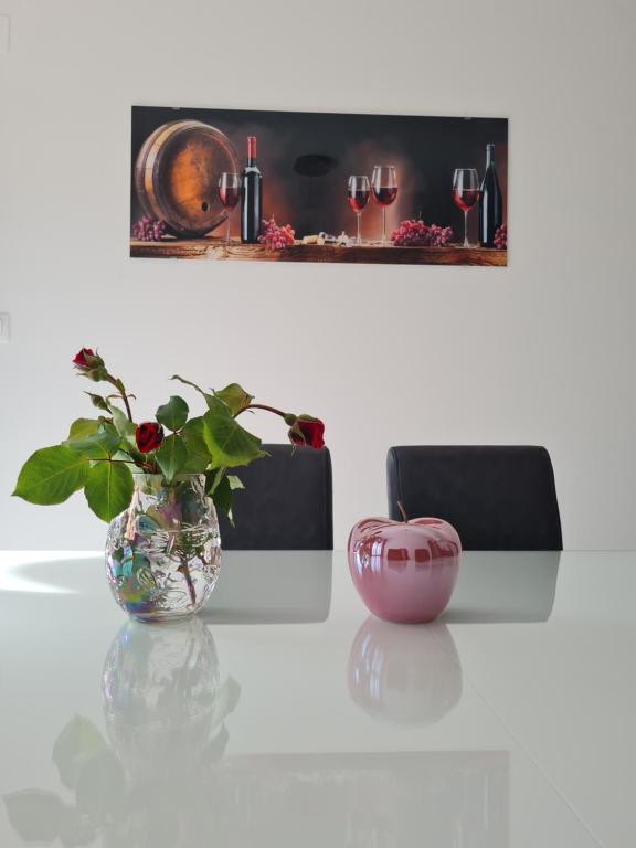 Una mesa blanca con un jarrón con una planta. en Apartman TESSA, en Vela Luka