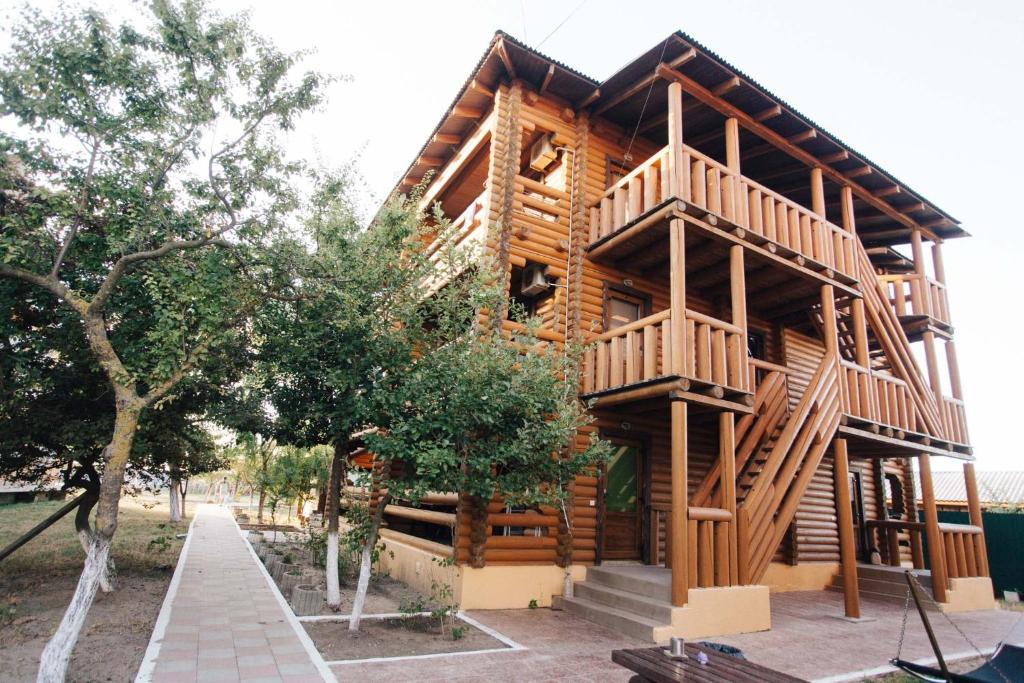 a wooden cabin with a balcony on the side of it at Nika2 Hotel in Zatoka