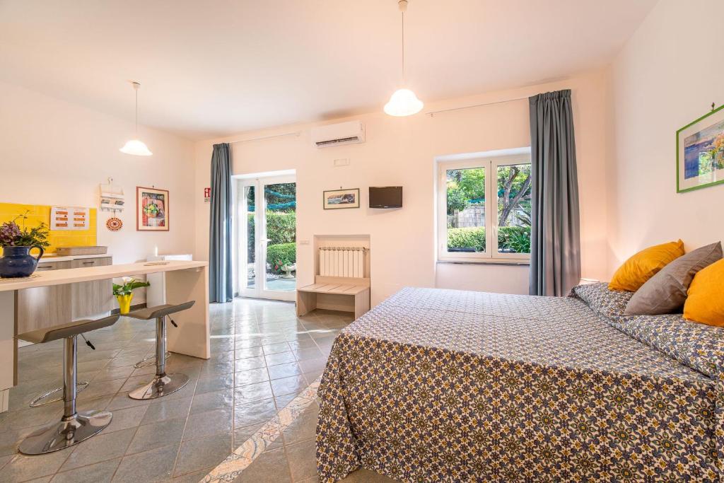 a bedroom with a bed and a desk and a kitchen at Casa Mary Family Apartment in Sorrento